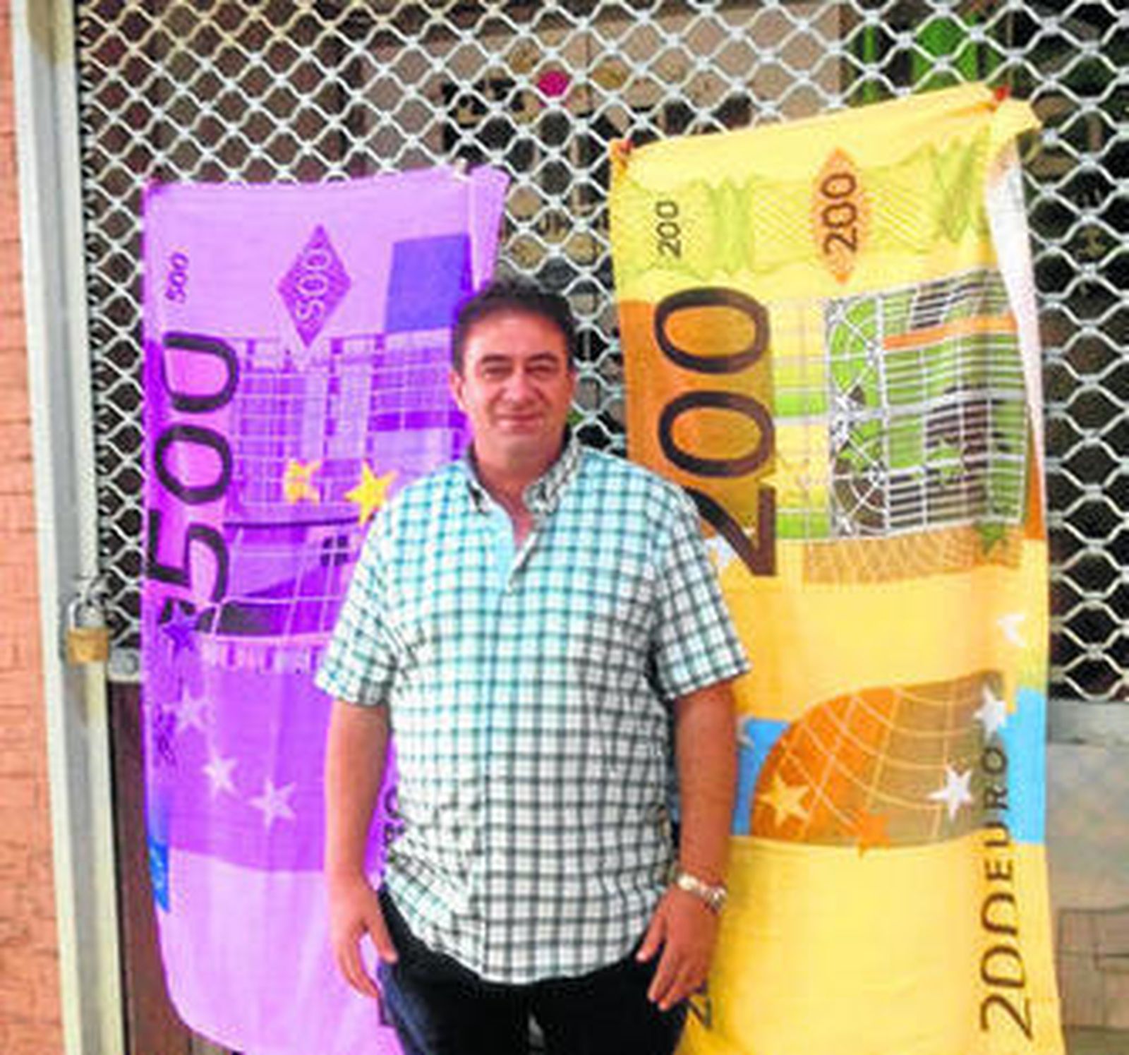 Un vendedor de prendas con billetes de 200 y 500 euros estampados.