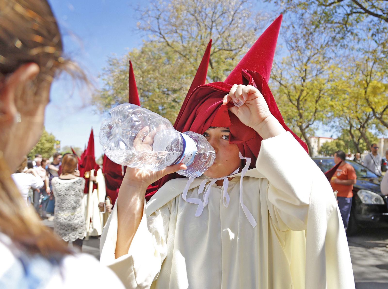 Las botellas de agua, tanto de la propia hermandad como de los familiares, no faltaron en el cortejo del Soberano Poder.