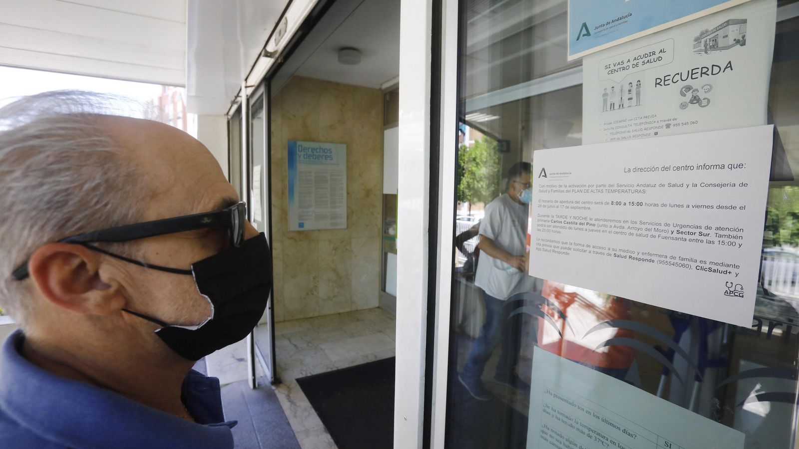 Un hombre lee el aviso sobre el horario de verano en los centros de salud.