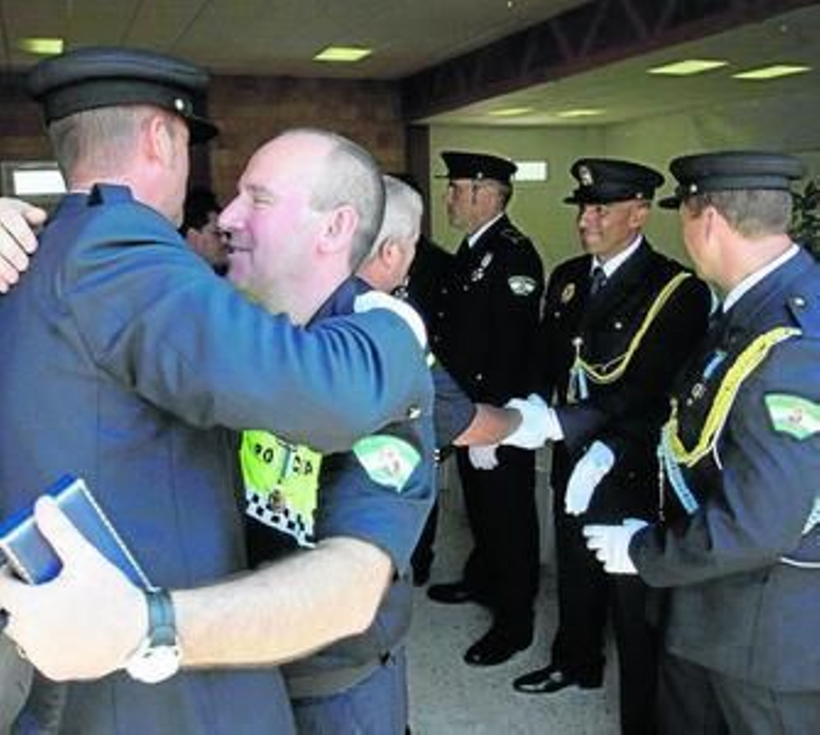 Un agente felicita a uno de sus compañeros, galardonado con la Cruz de la Constancia.