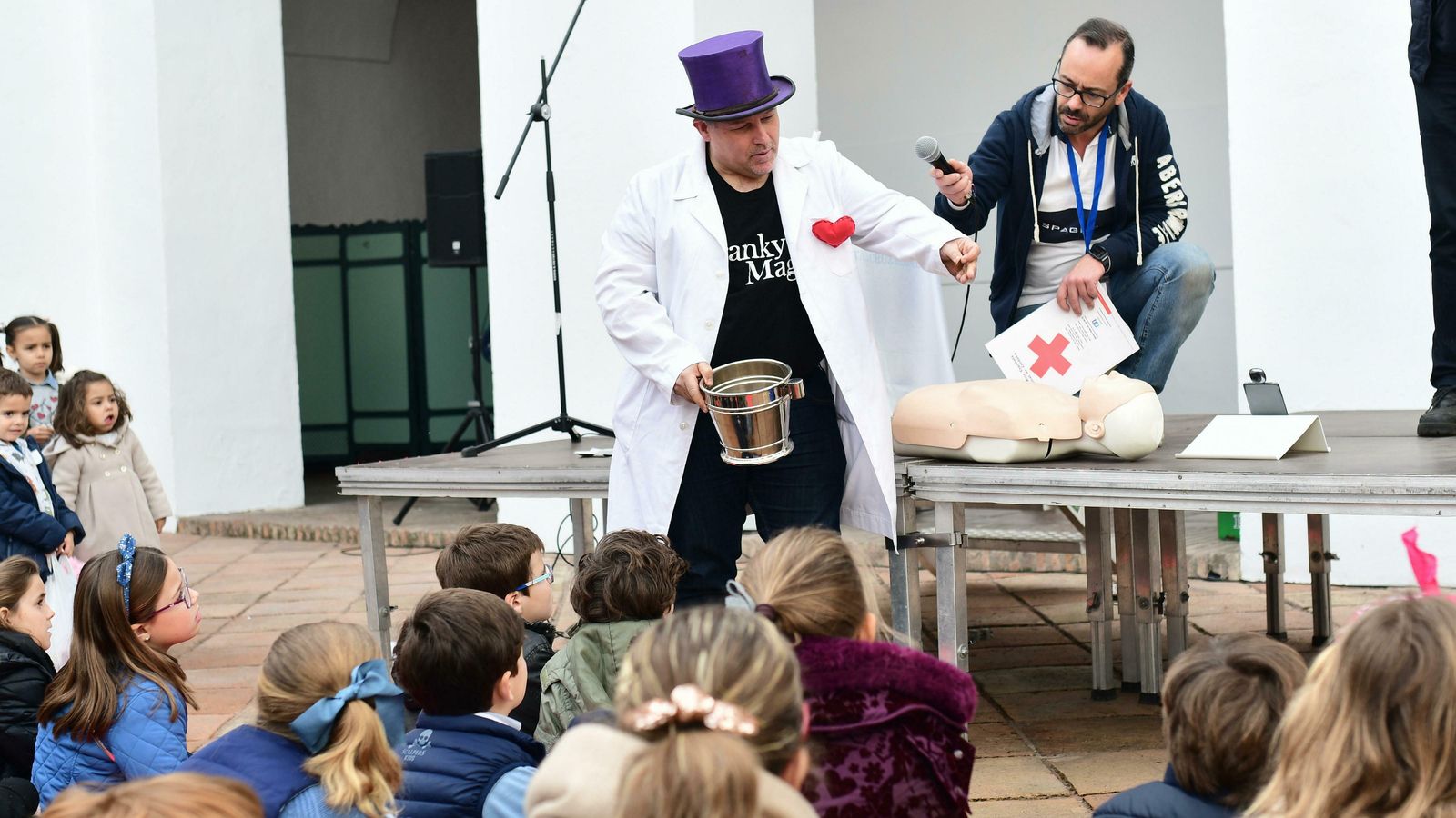 Un mago enseña a los niños RCP básica con trucos de magia.
