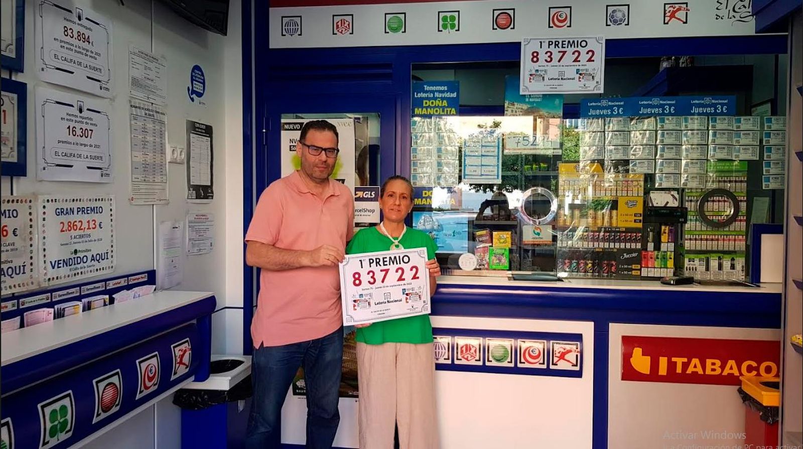 Agustín Hidalgo y su mujer sujetan un cartel con el número premiado.