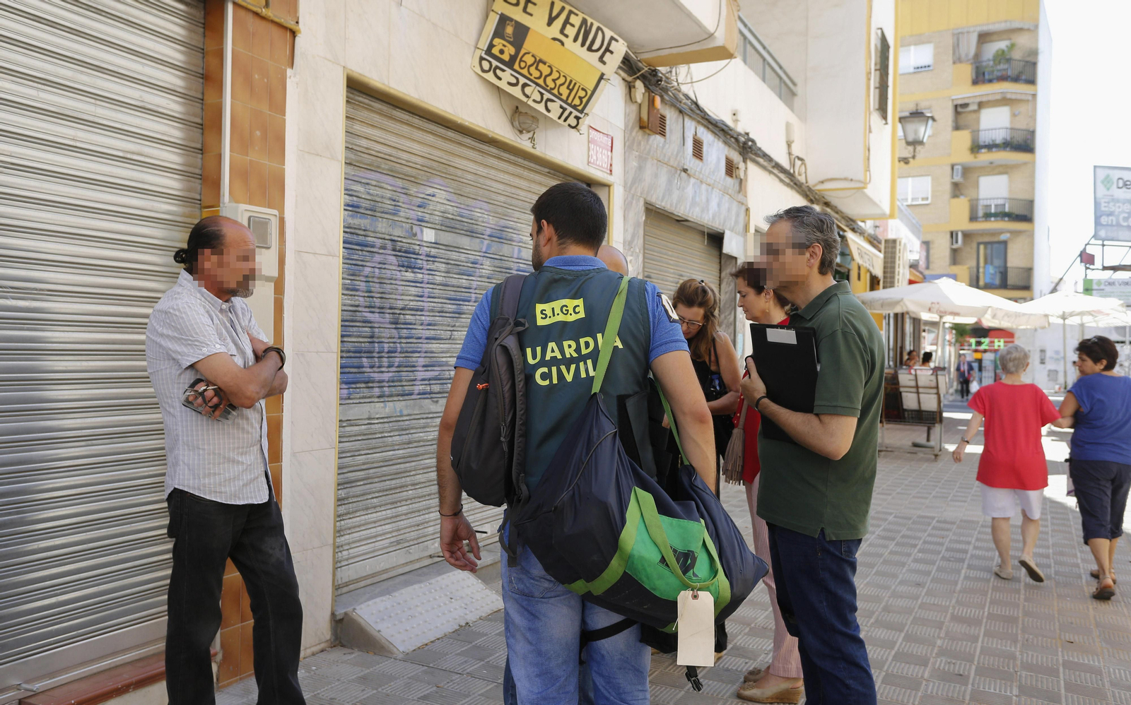 Uno de los sospechosos, custodiado ayer por la Guardia Civil, durante el registro de un local en la calle Emilio Prados, junto a Pino Montano.