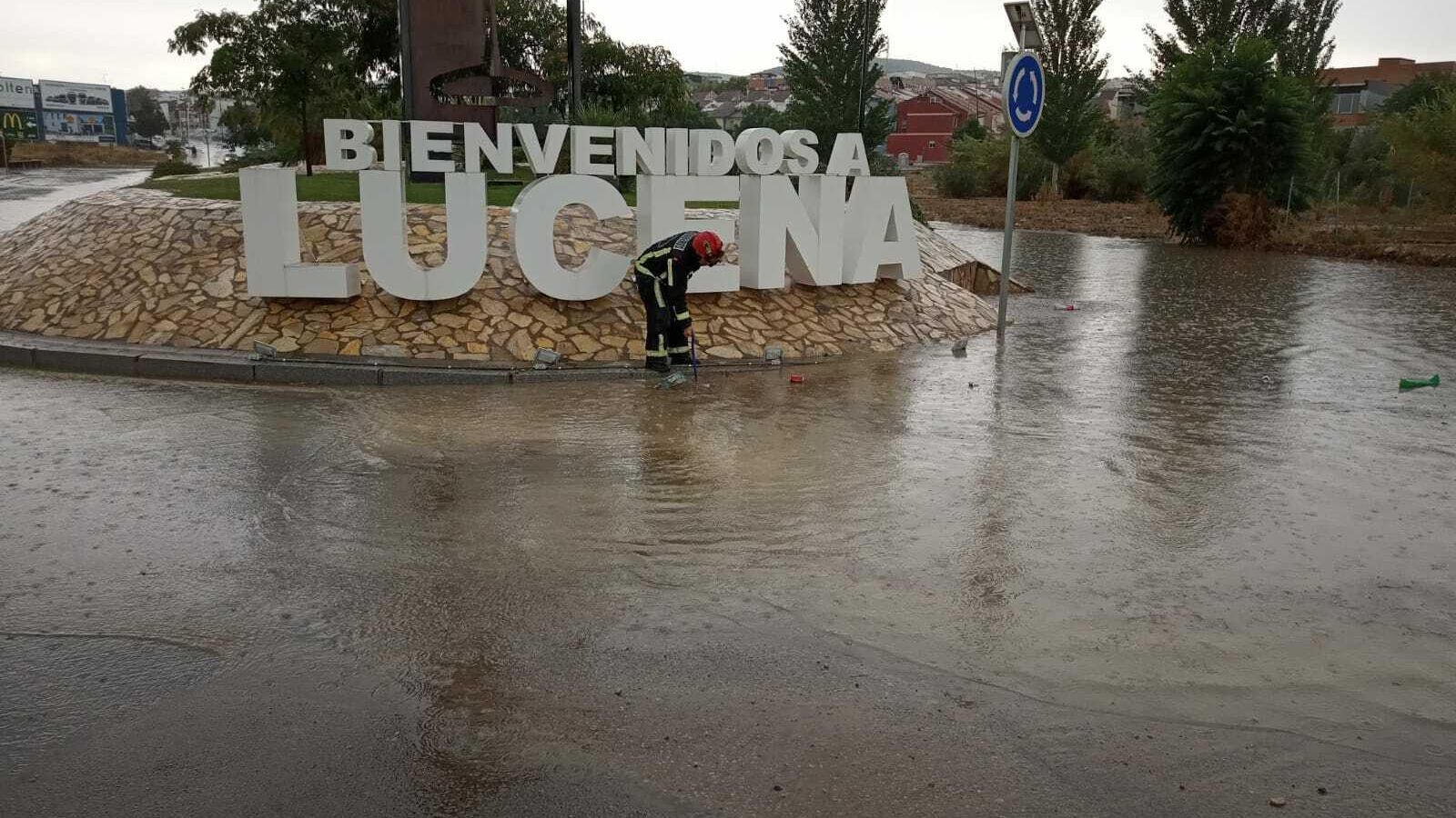 Un bombero en la rotonda de la puerta de Córdoba de Lucena.