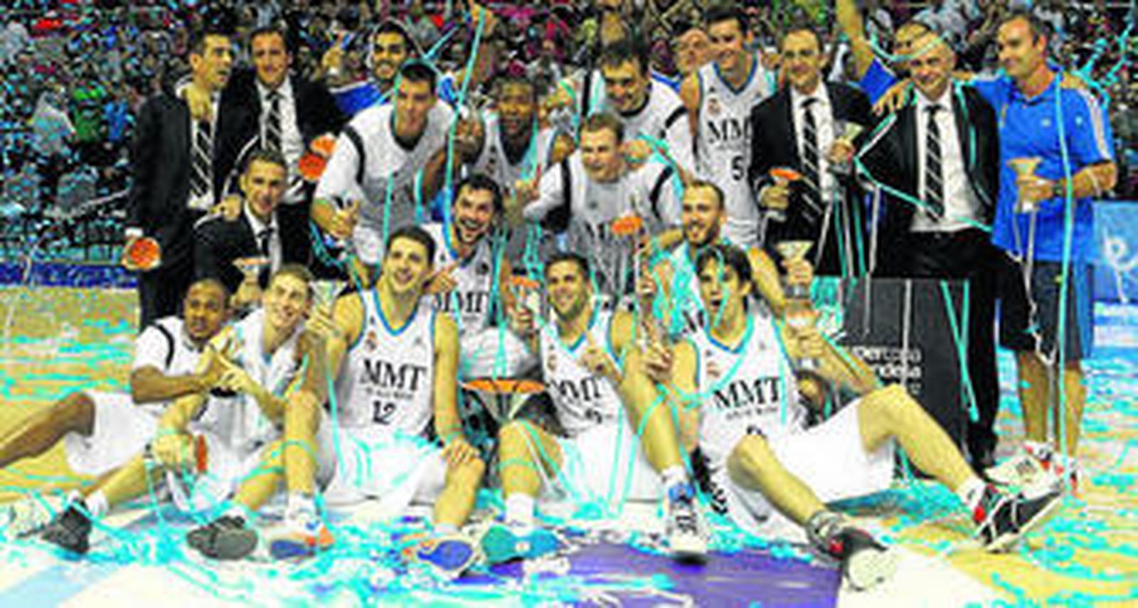 Los jugadores y los técnicos del Madrid posan sobre el parqué con el trofeo de la Supercopa.