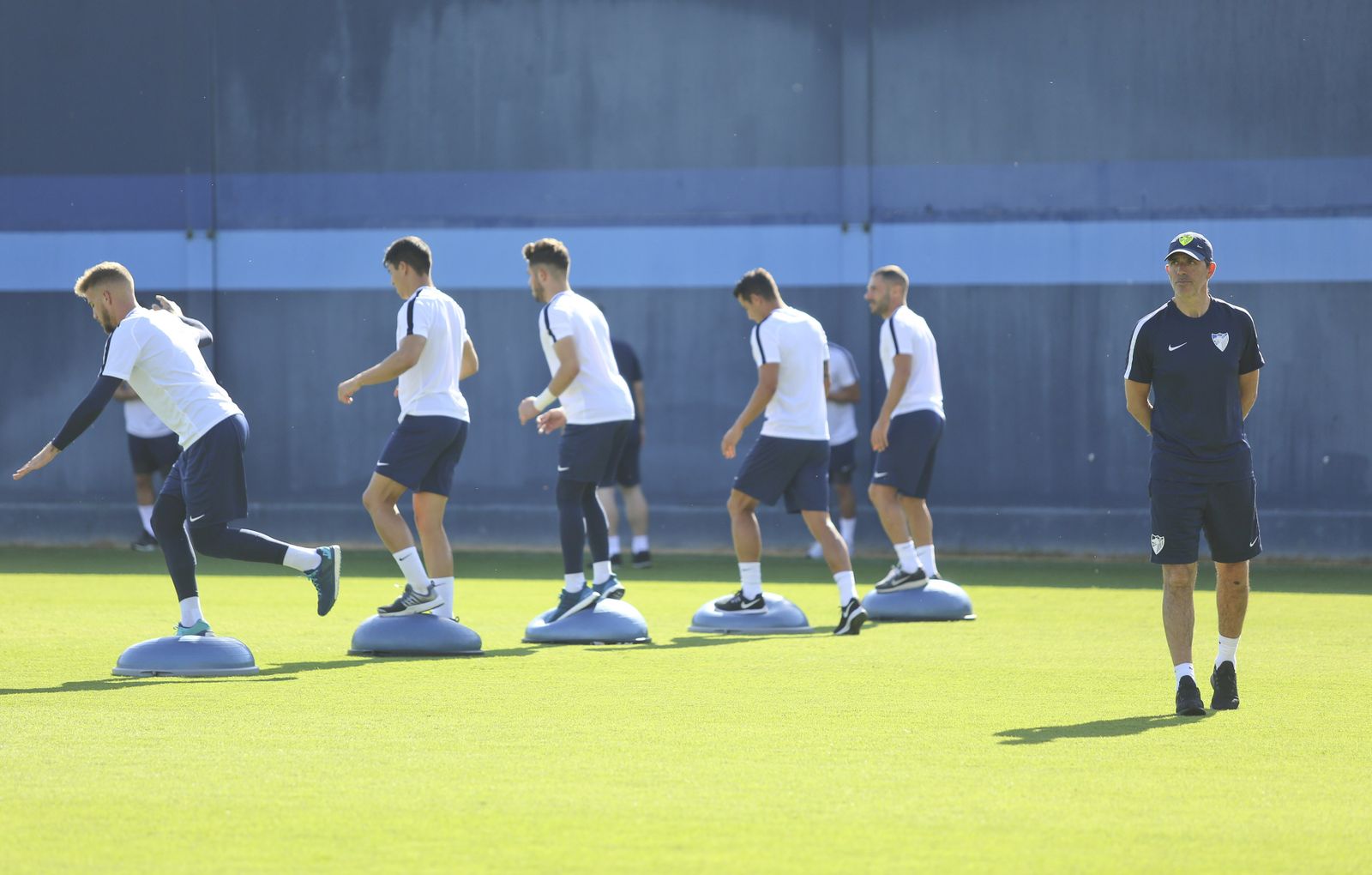 Muñiz camina por el césped del Anexo de La Rosaleda mientras sus jugadores hacen ejercicios de equilibrio.