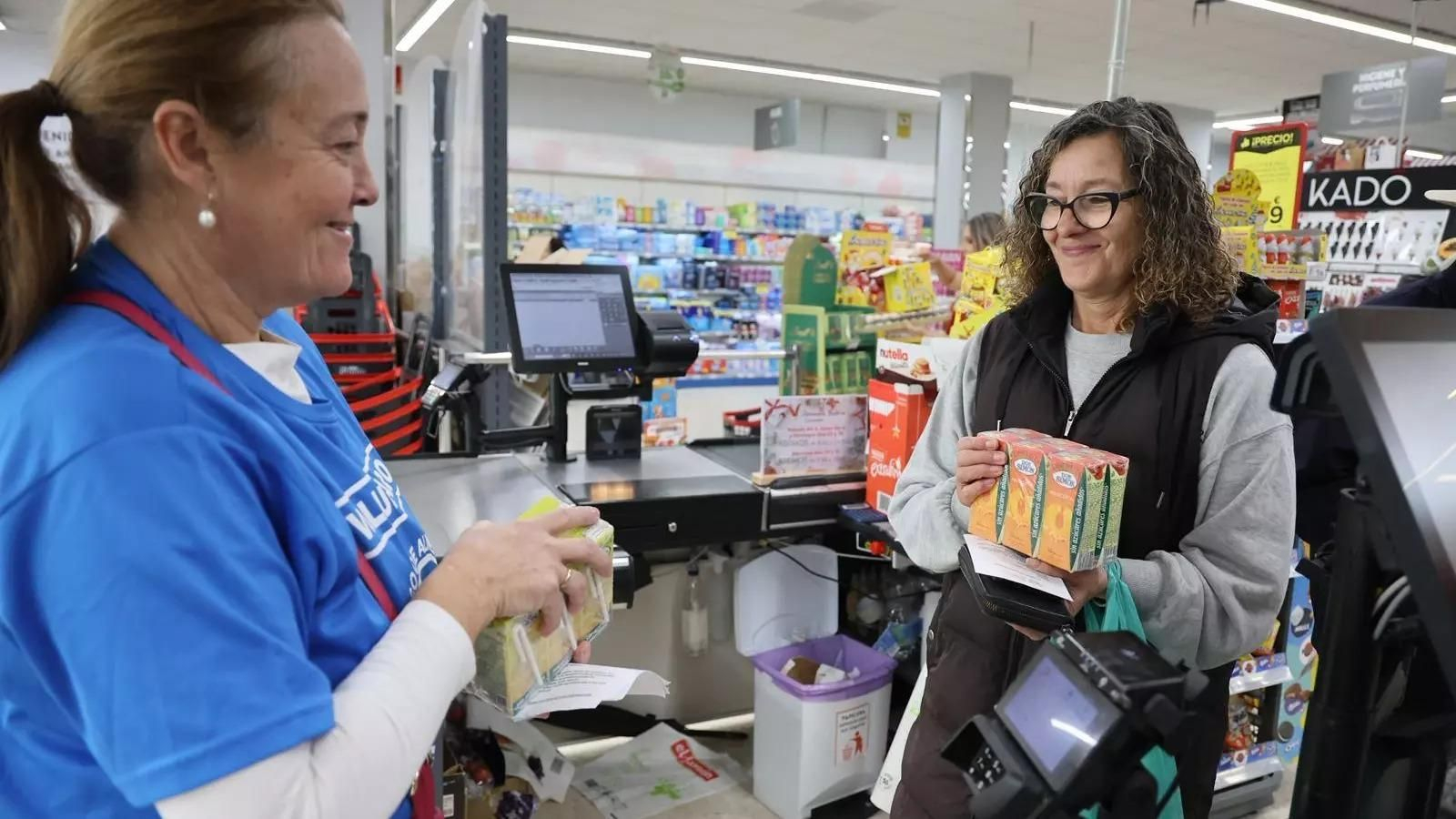 Una mujer realiza una donación al Banco de Alimentos.