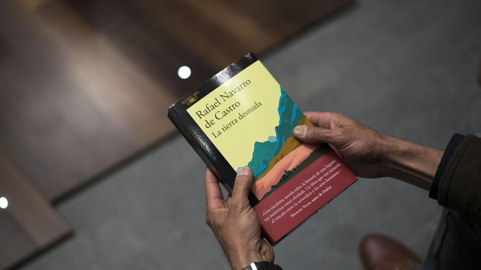 Navarro sostiene su primer libro, 'La tierra desnuda', avalada por el escritor Manuel Vilas.