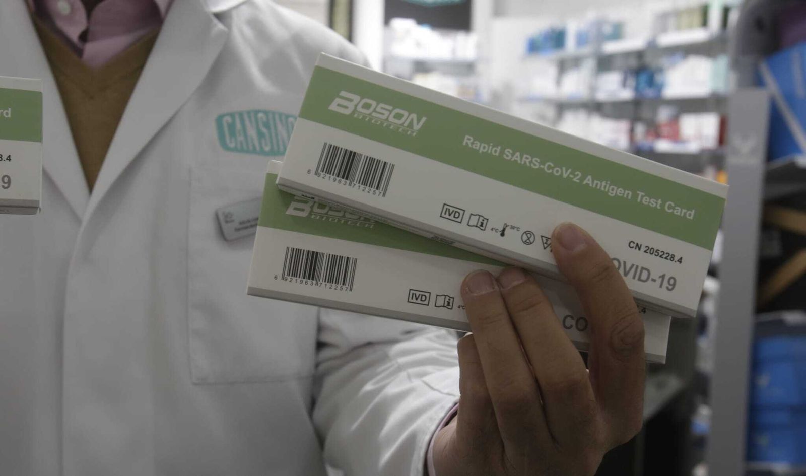 El farmacéutico sevillano Julio Cansino muestras dos ejemplares de test de antígenos a la venta.