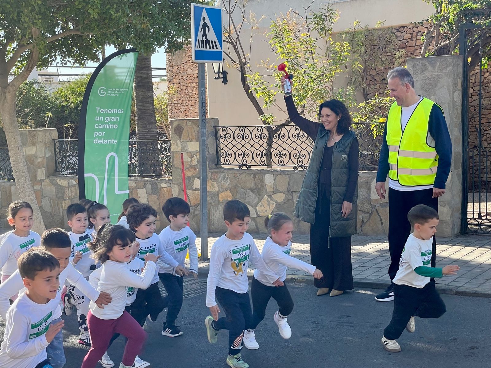 La presidenta de la AECC y el director del CEIP Francisco de Goya dan la salida de la carrera en el Día de Andalucía.