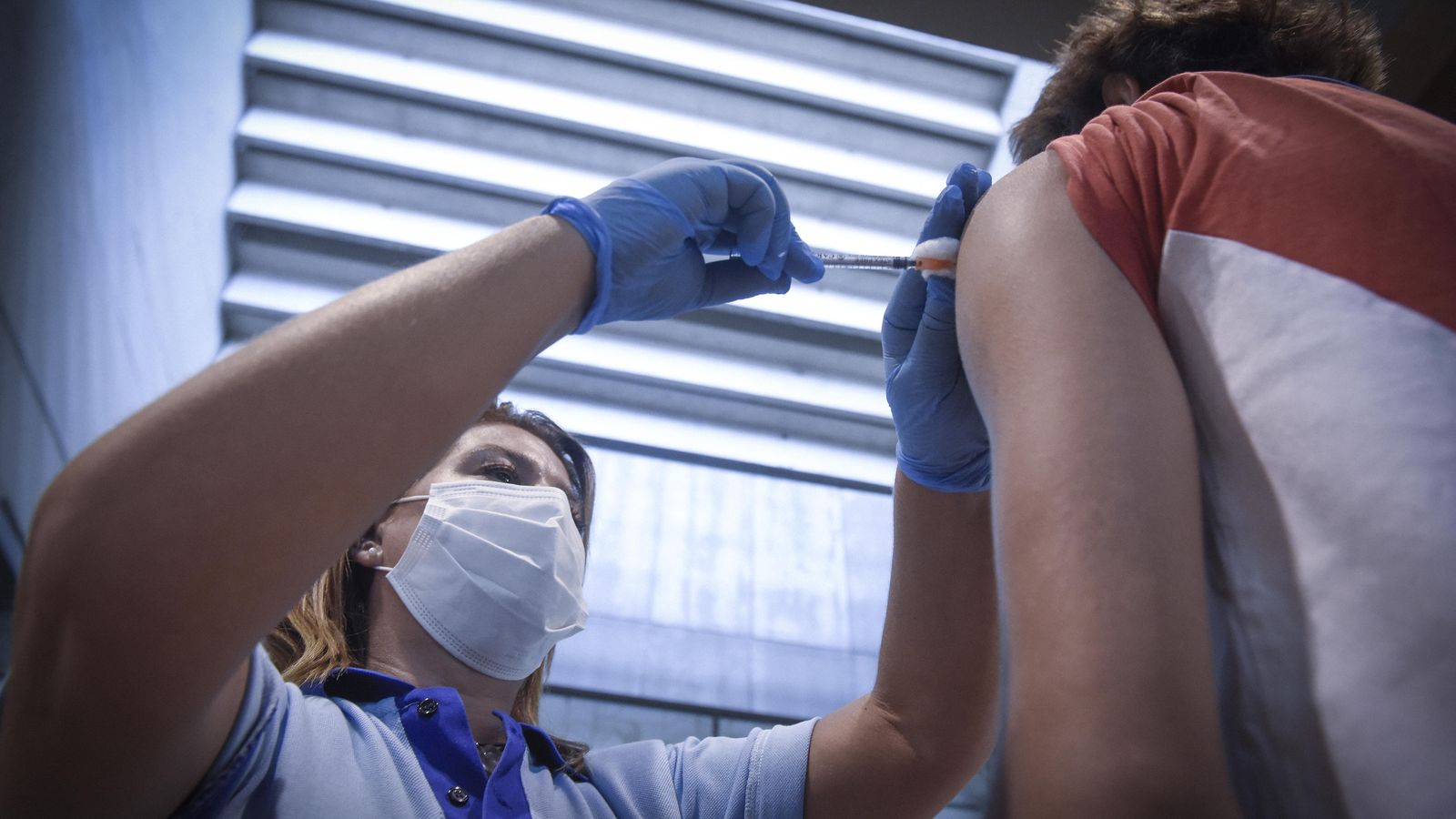 Una enfermera vacuna a un joven en el Estadio de la Cartuja.