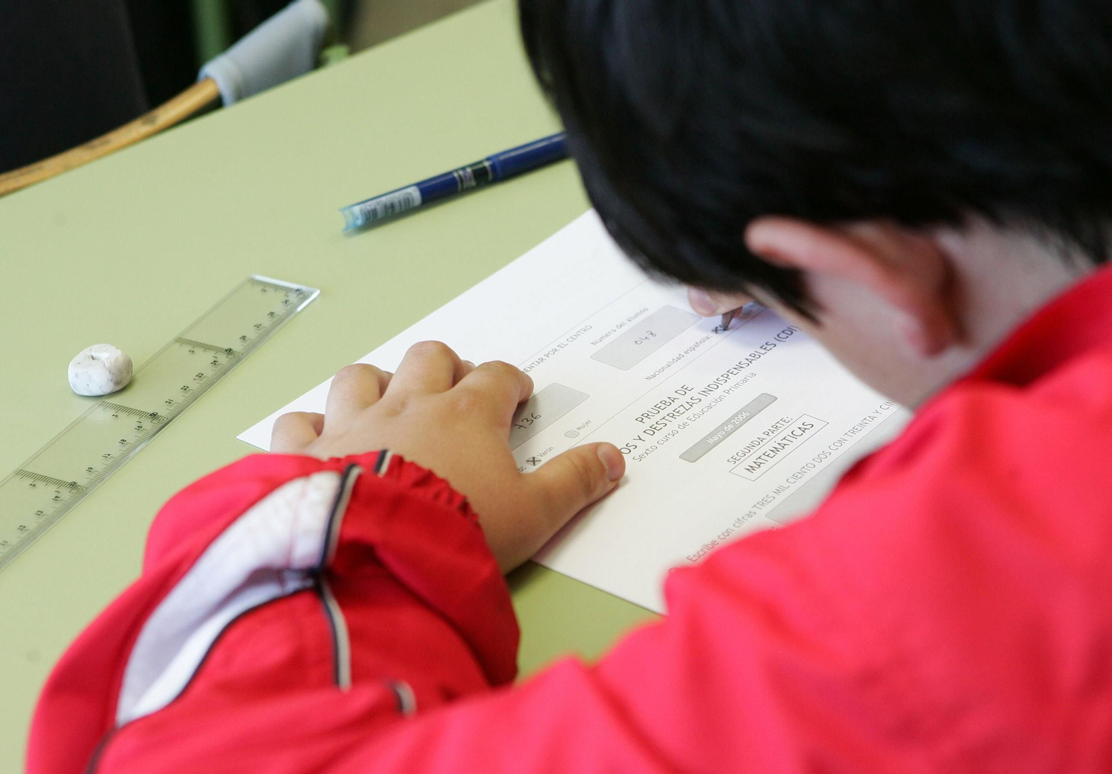Un niño realiza un ejercicio en un colegio.