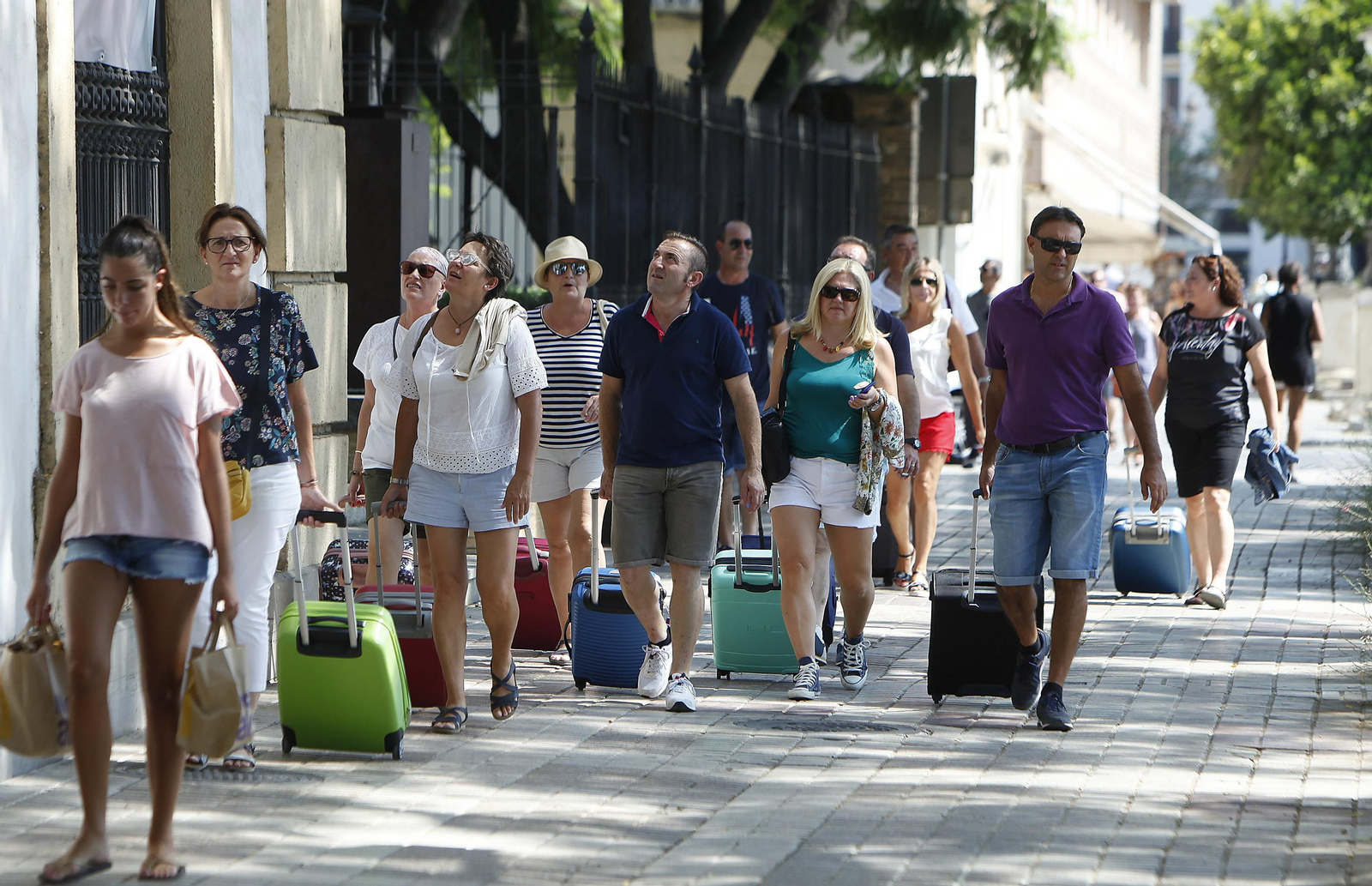 Un grupo de turistas observa los edificios en Sevilla.
