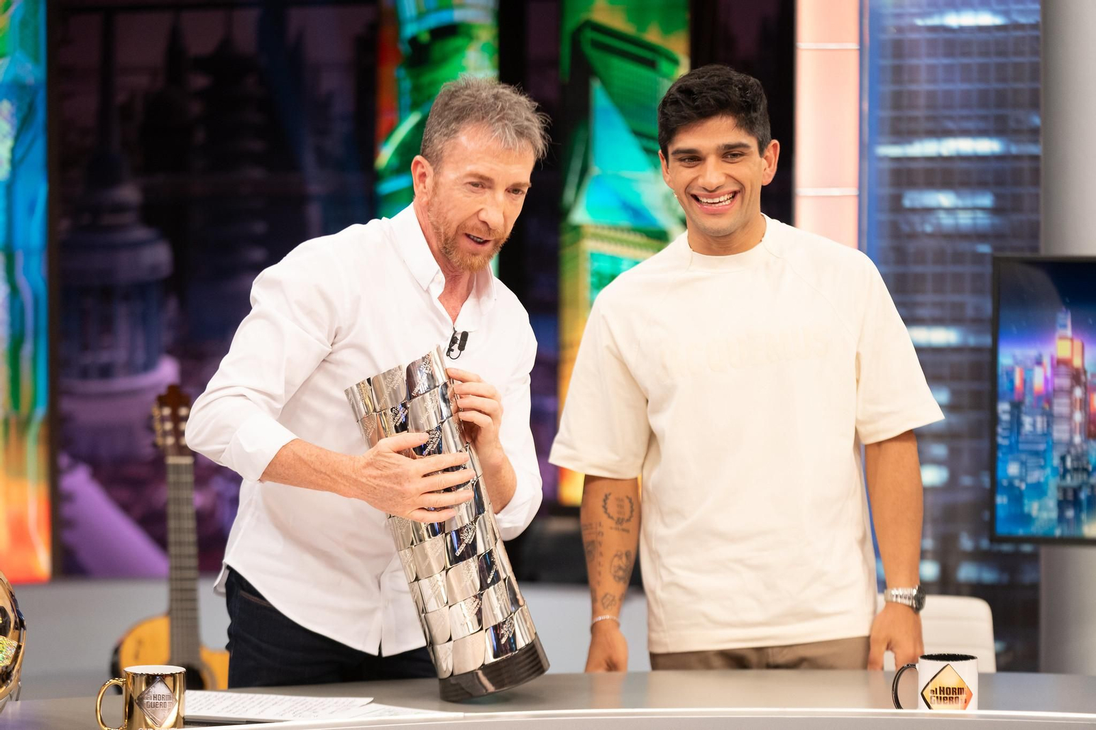 Pablo Motos enseña los nombres de la copa del Mundial de Moto GP ante su vigente campeón, Jorge Martín, este miércoles en 'El Hormiguero'