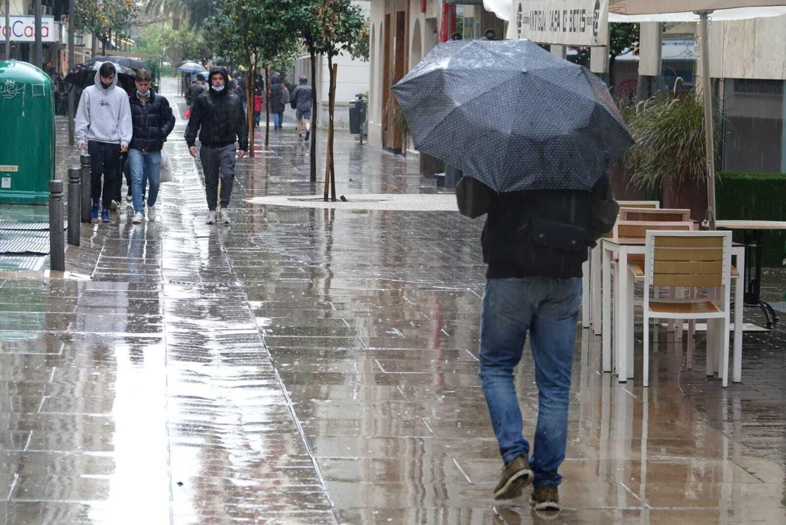 Una persona camina por el centro de Málaga, este viernes, en un día de lluvia.