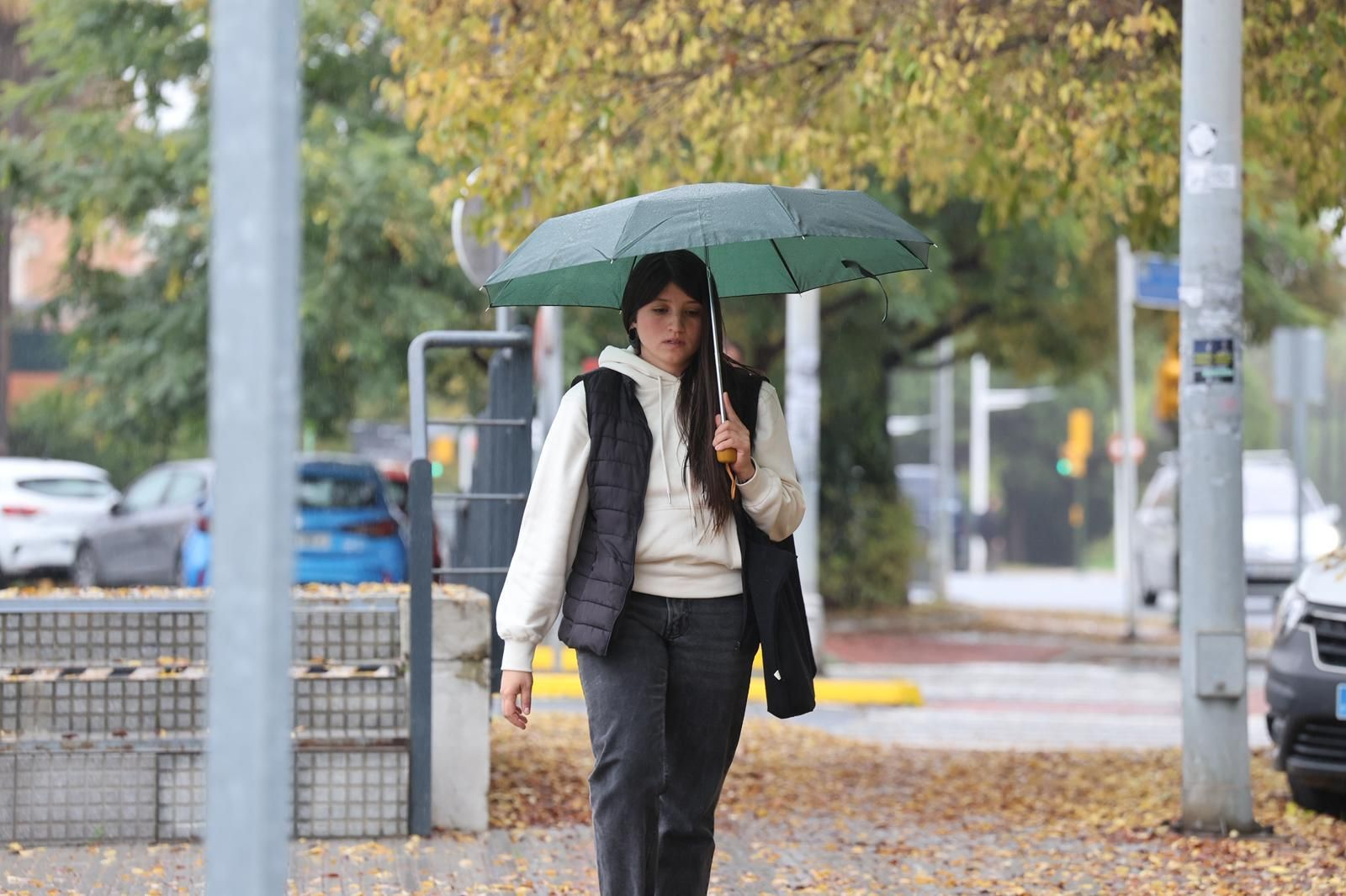 Una persona se refugia de la lluvia en Huelva.