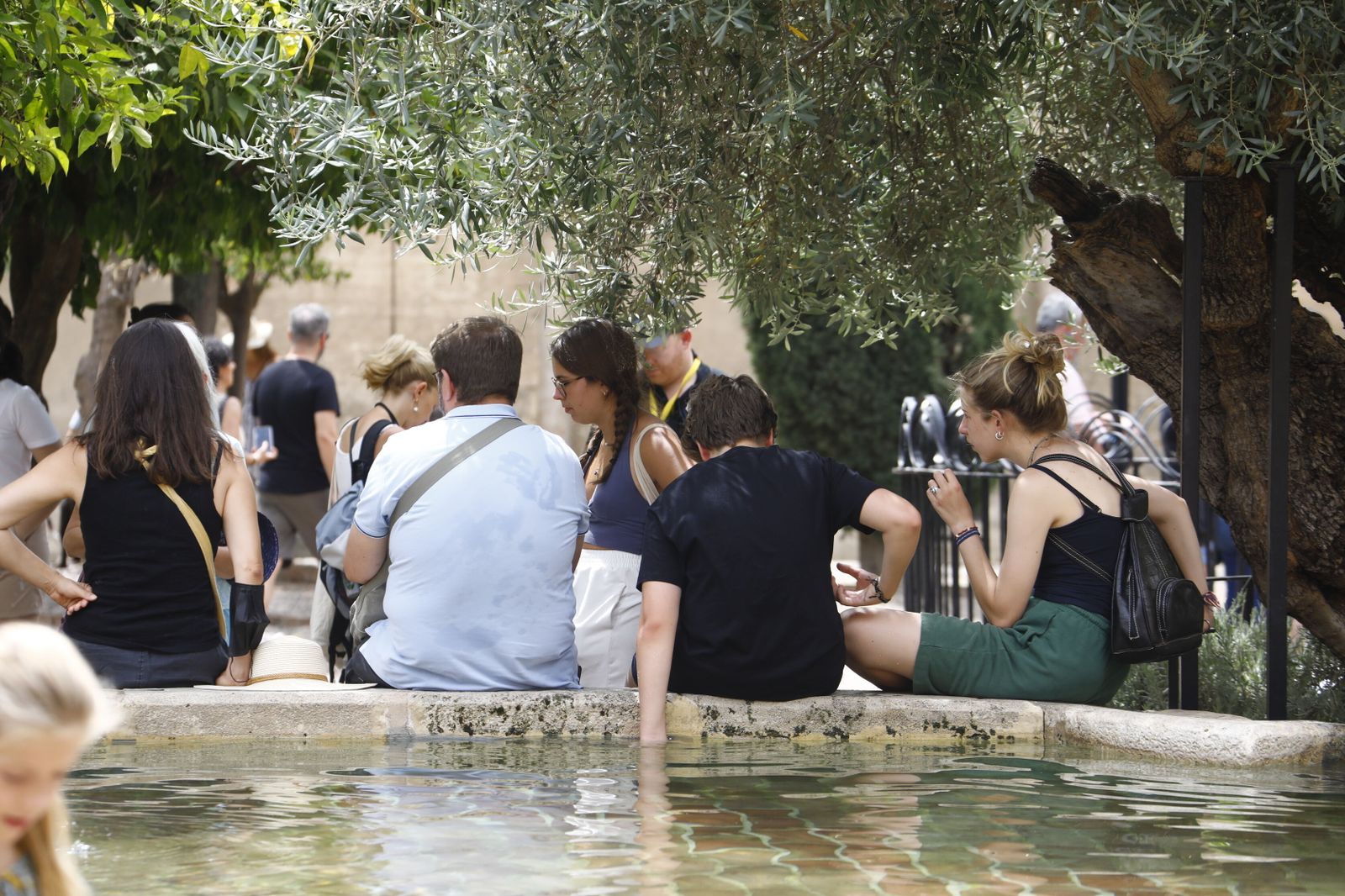 Turistas se refrescan en el Patio de los Naranjos de la Mezquita-Catedral.
