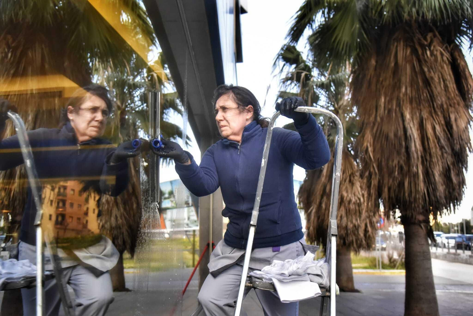 Una persona limpia el ventanal de un edificio en Algeciras, este jueves.