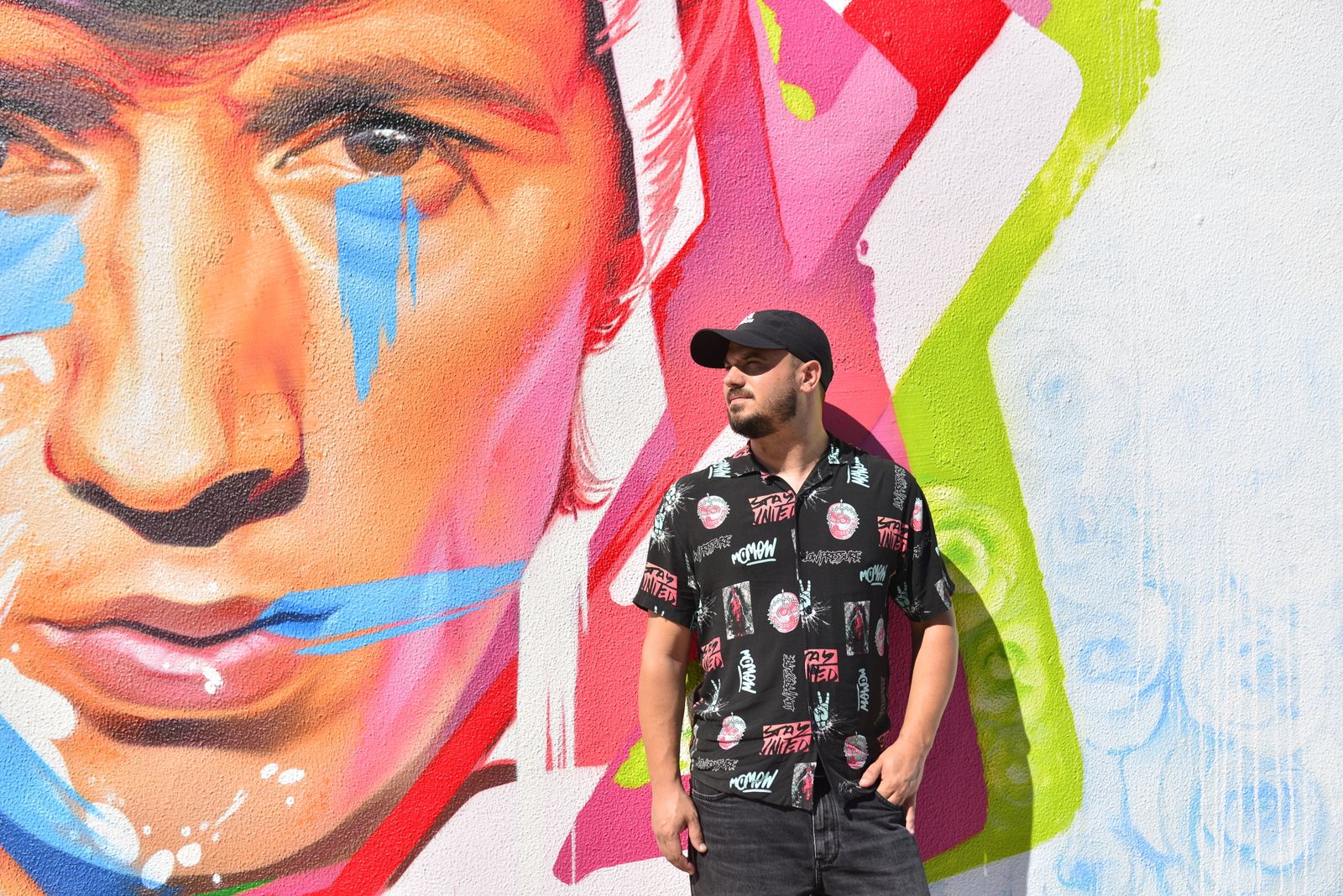 El grafitero Man-o-Matic posa con el grafiti de Bambino en la ciudad natal del artista, Utrera.