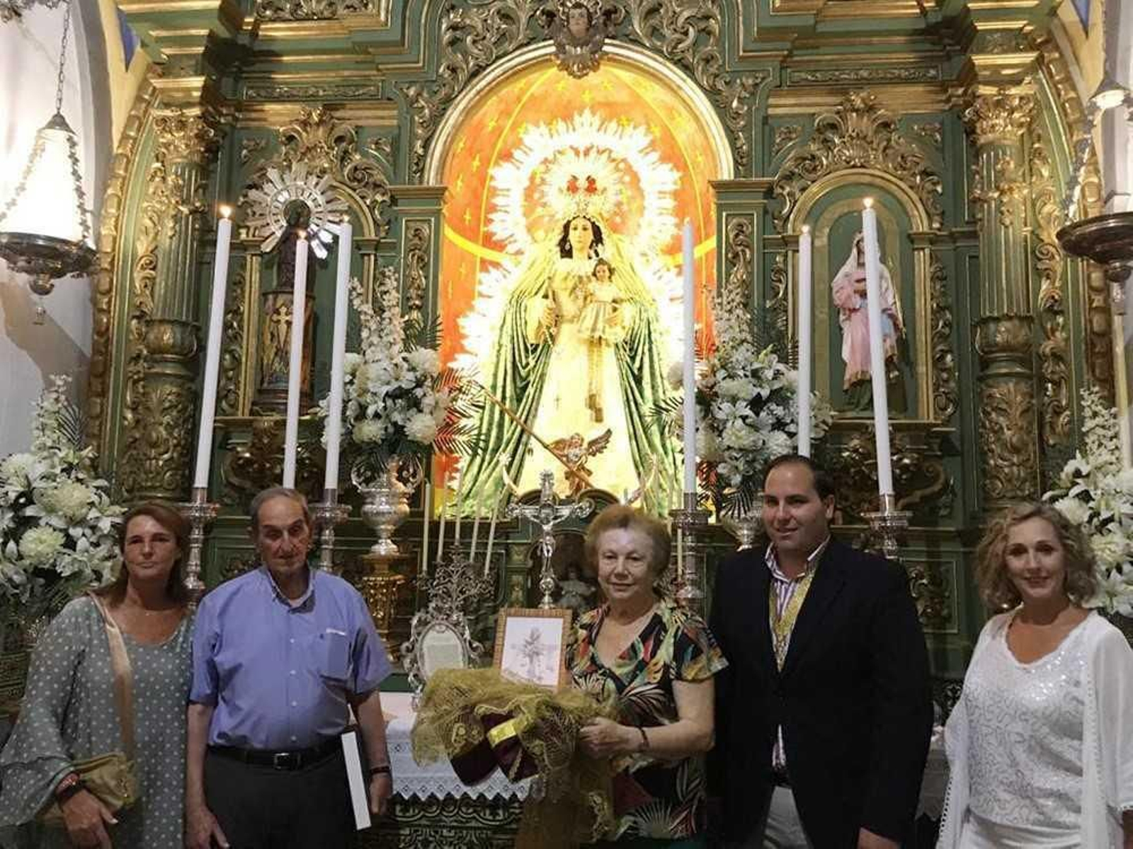 La autora hace entrega de su trabajo artesanal a la hermandad catayera.