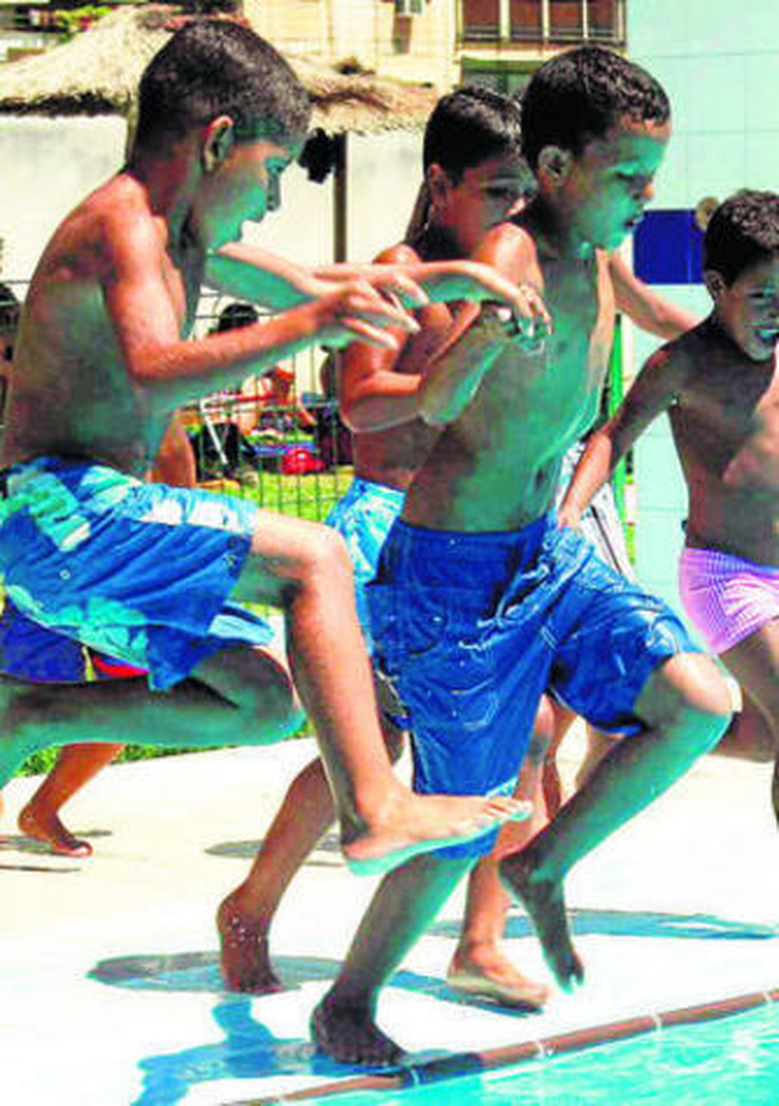 Un grupo de niños juega en una piscina.