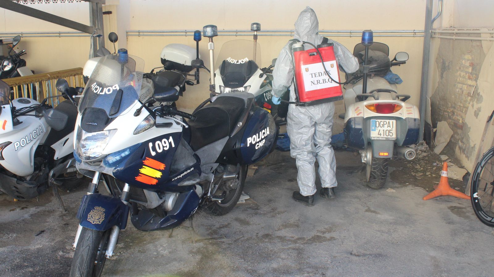 Un agente de los Tedax-NBRQ de la Comisaría Provincial de Almería desinfecta motos de la Policía Nacional.