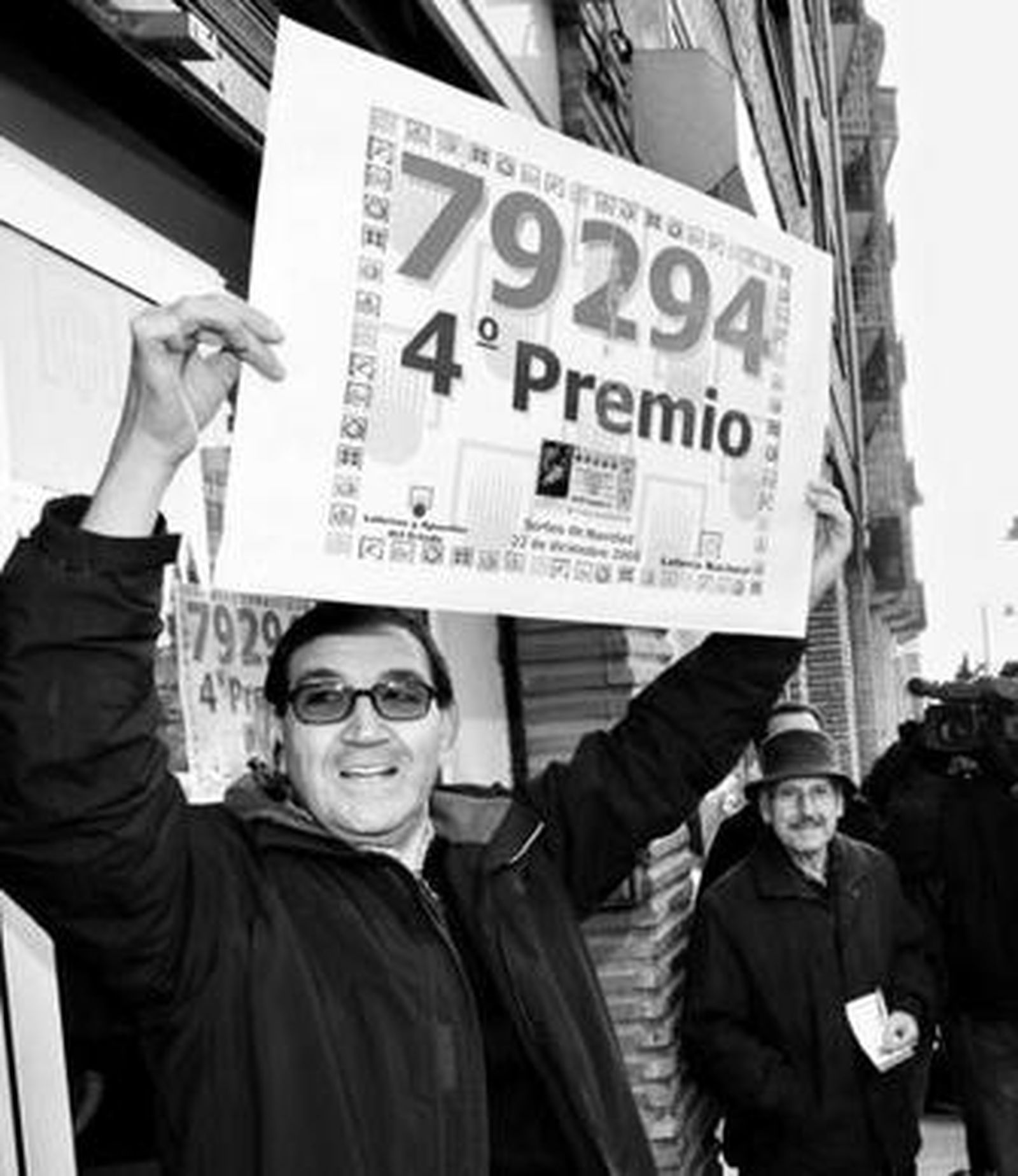 El lotero Ángel Fernández celebra el número premiado.