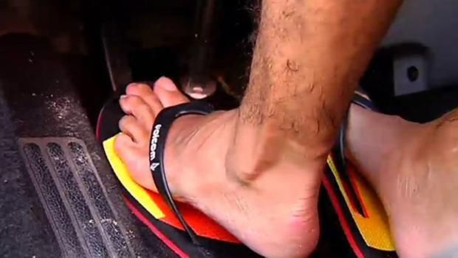 Un hombre conduciendo con chanclas