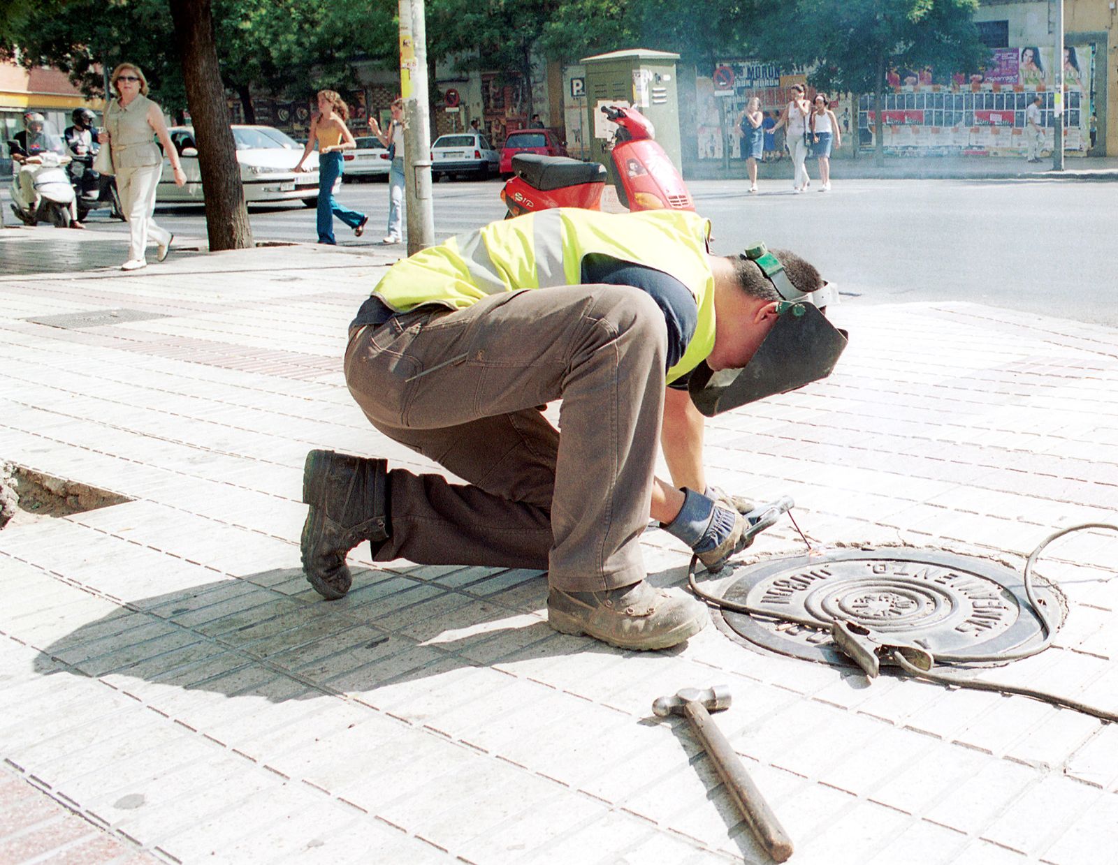 Un operario trabaja sobre una alcantarilla.