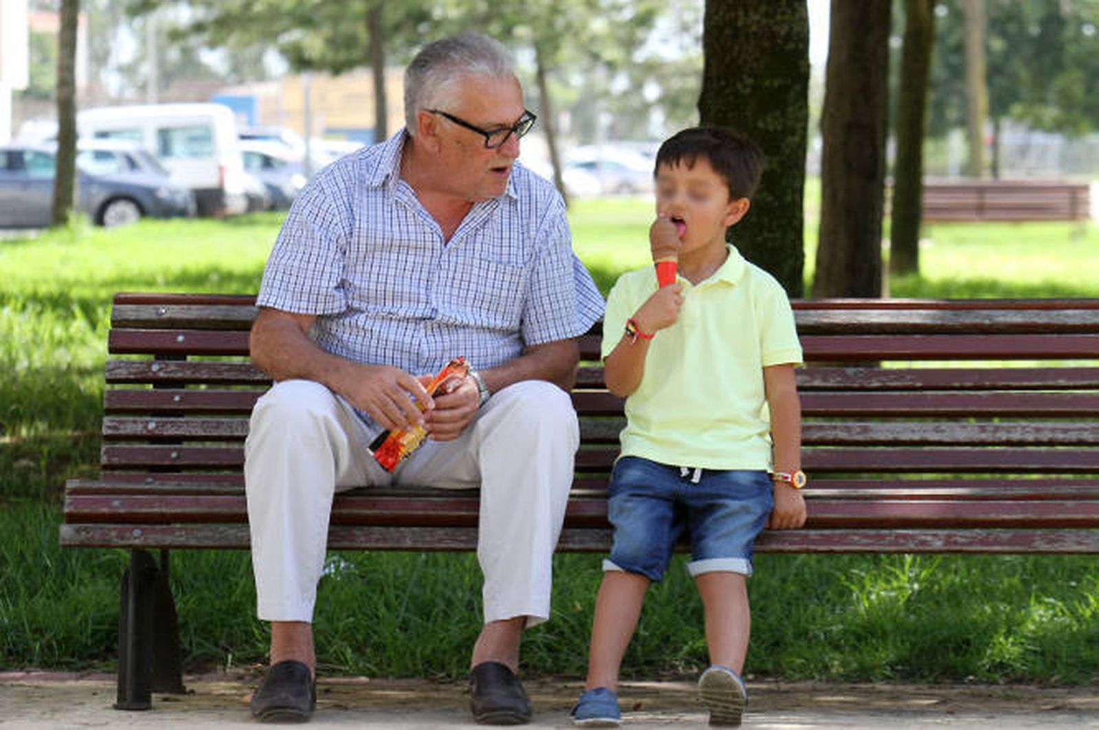 Un abuelo pasa la tarde con su nieto en el parque.