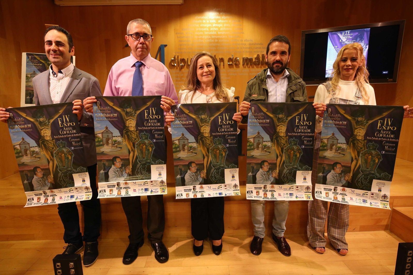Los organizadores muestran carteles de la exposición.