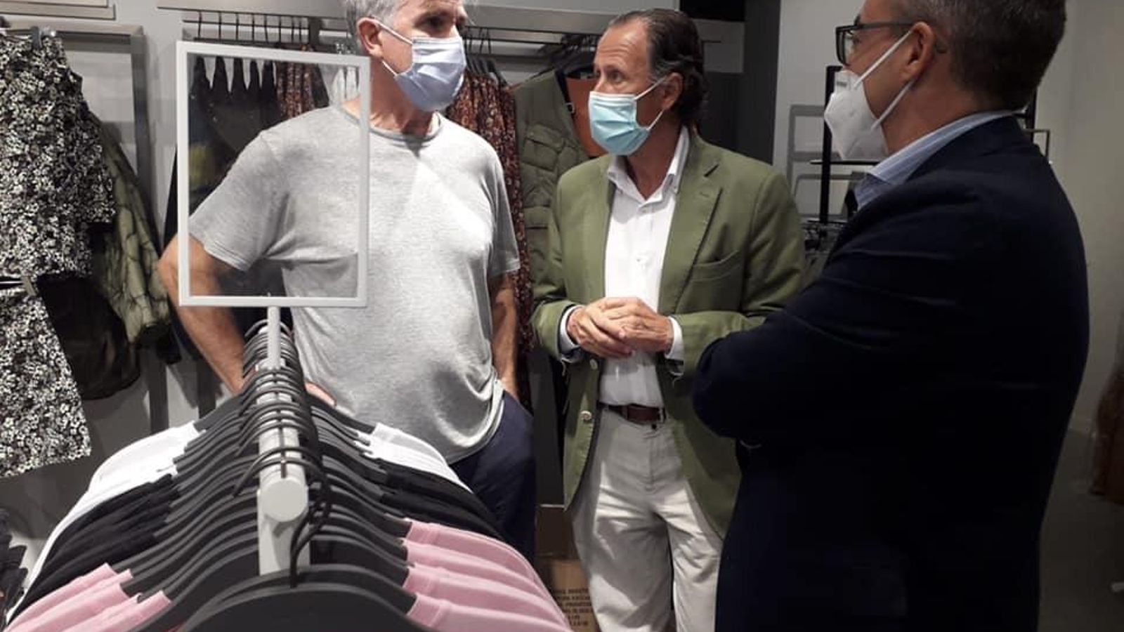El gerente de la tienda conversa con el alcalde y el teniente de alcalde durante la inauguración.