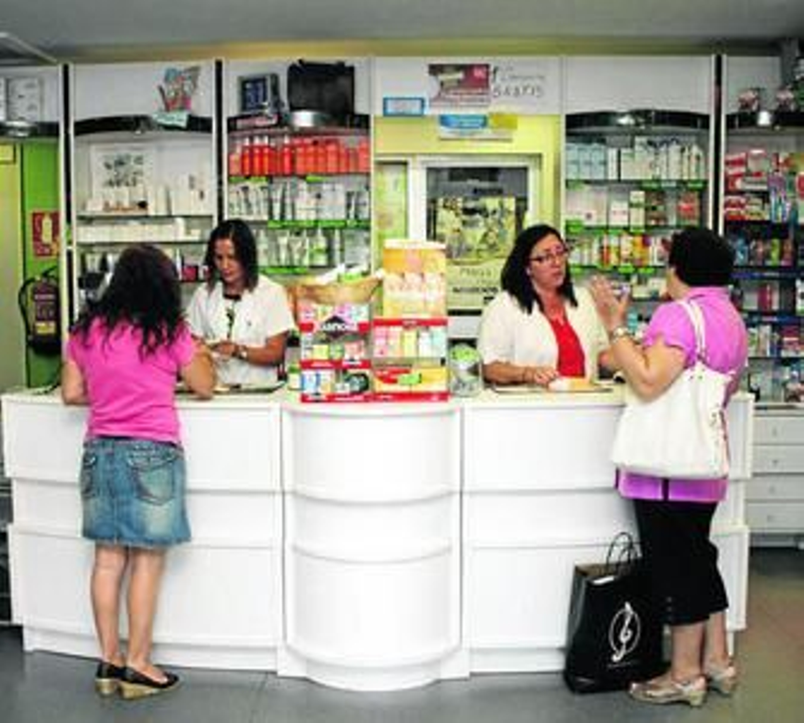 Unas clientas hacen una compra en una farmacia.
