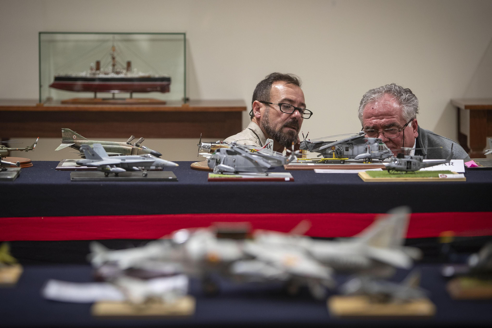 Dos personas observan los detalles de la maqueta de un helicóptero.