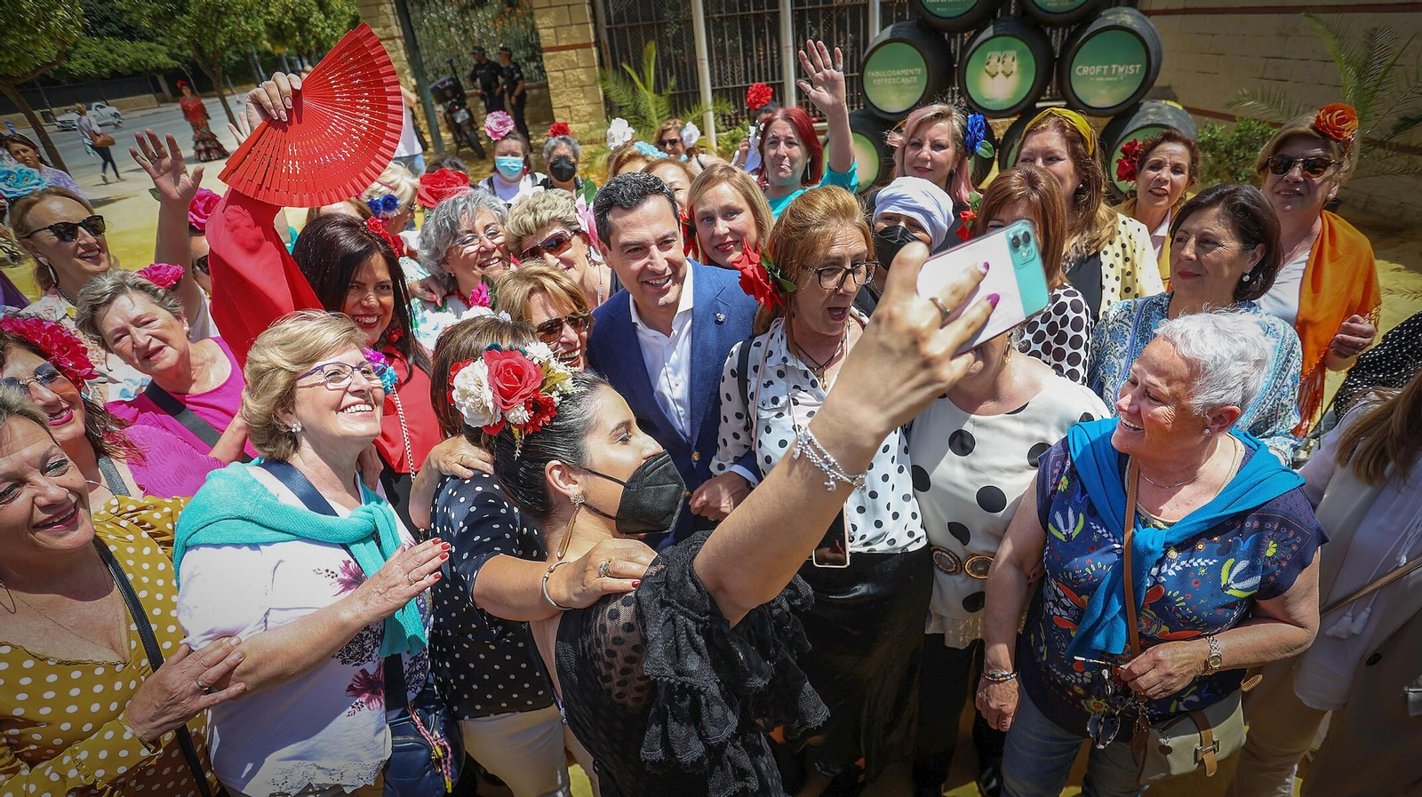 Juanma Moreno se fotografía este jueves con un grupo de mujeres en la Feria de Jerez.