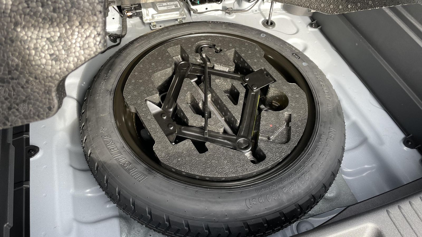 Bajo el bloque de poliexpán hay una buena noticia: una rueda de repuesto, aunque sea de tipo galleta.