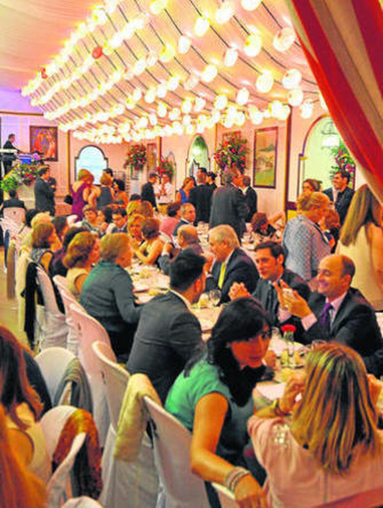 Farolillos presidiendo la cena del 'pescaíto' en una de las casetas.