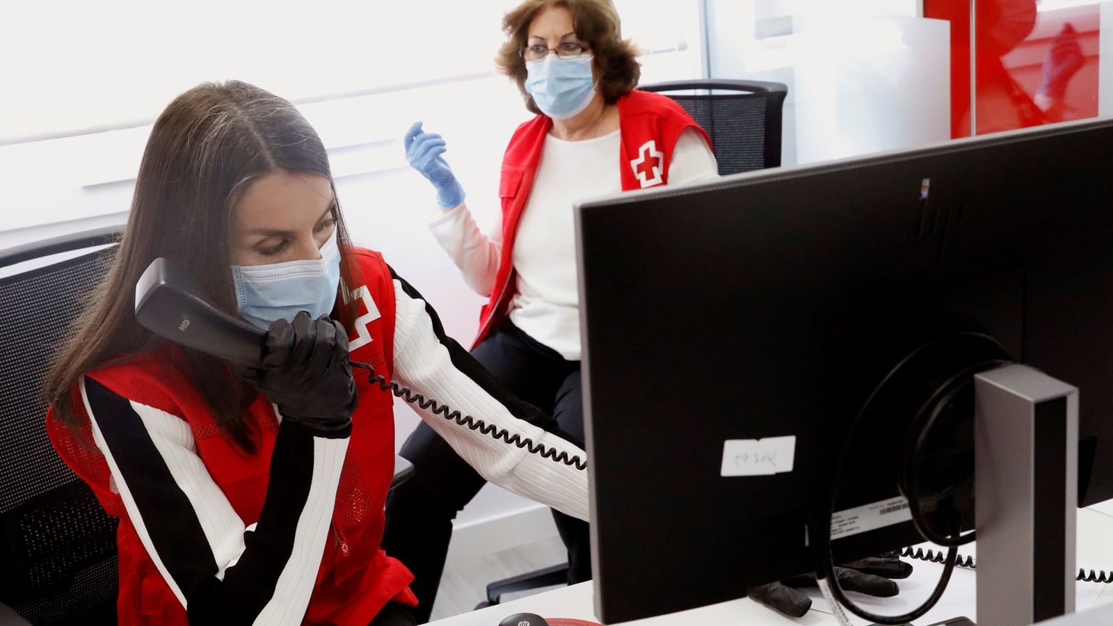 La Reina charla con una de las personas mayores que recibe ayuda de Cruz Roja.