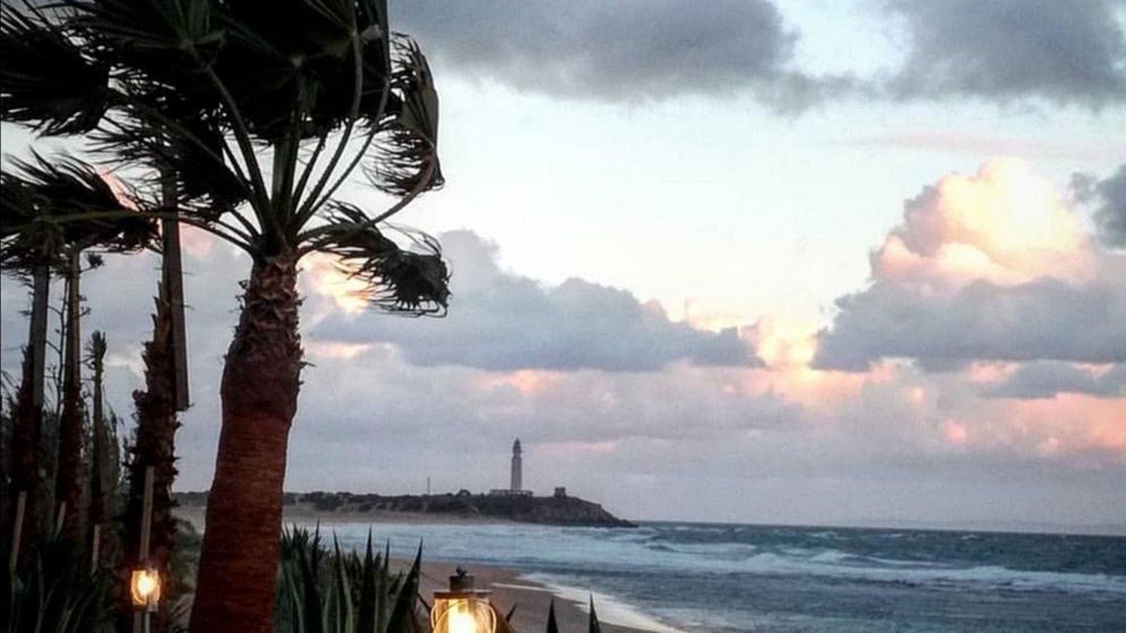 Imagen que reflejan la belleza de la playa de Zahora al atardecer, con el faro de Trafalgar al fondo.