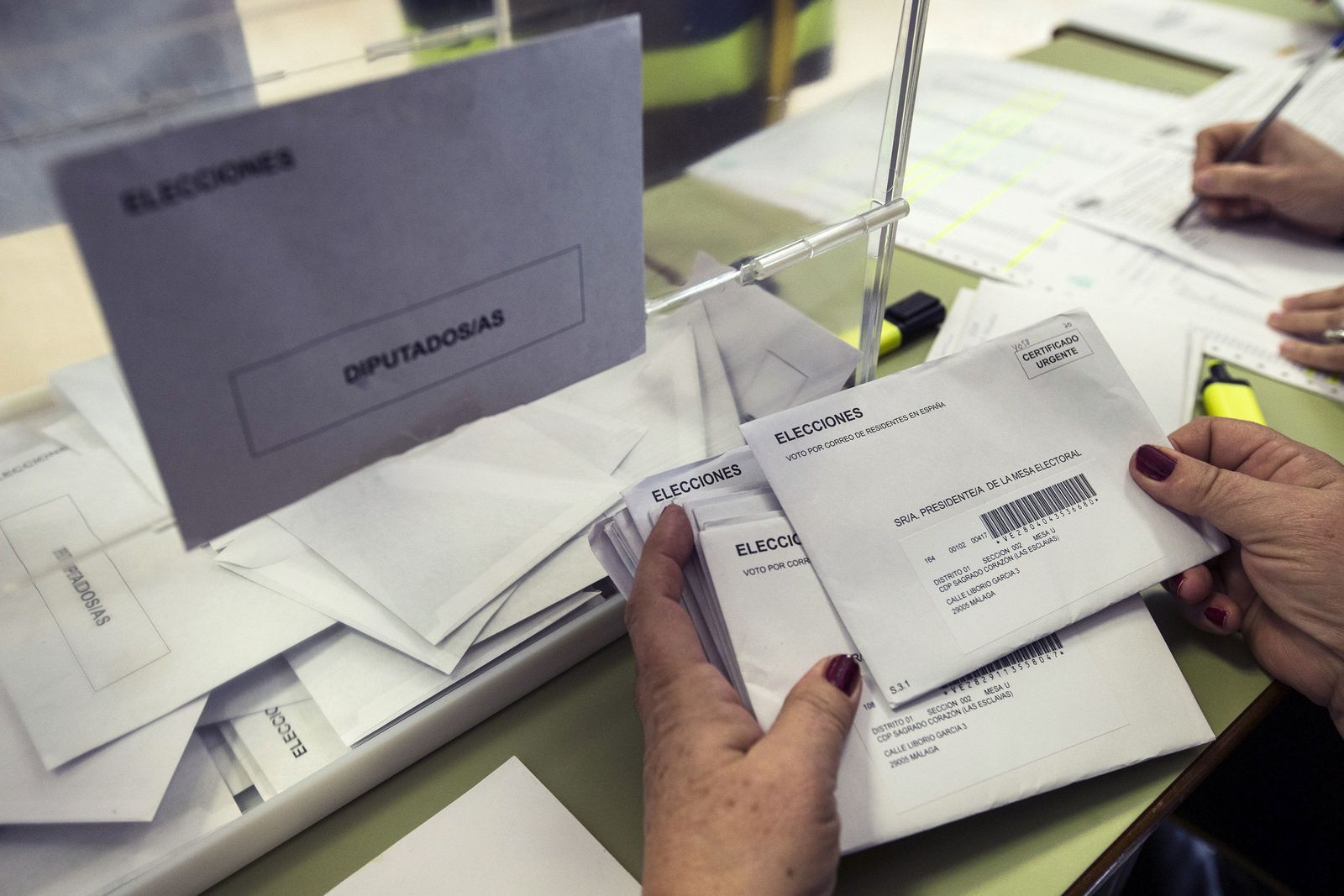 La presidenta de una mesa electoral hace recuento de los votos por correo recibidos.