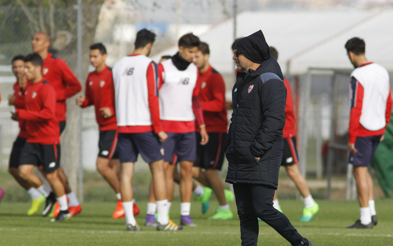 Jorge Sampaoli, pensativo en la ciudad deportiva mientras se ejercitan los jugadores al fondo.