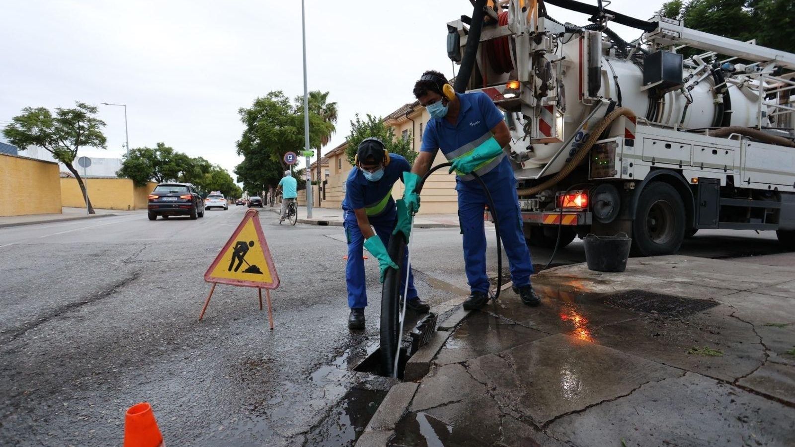 Dos operarios limpiando un imbornal en uana calle de Jerez en una imagen de archivo