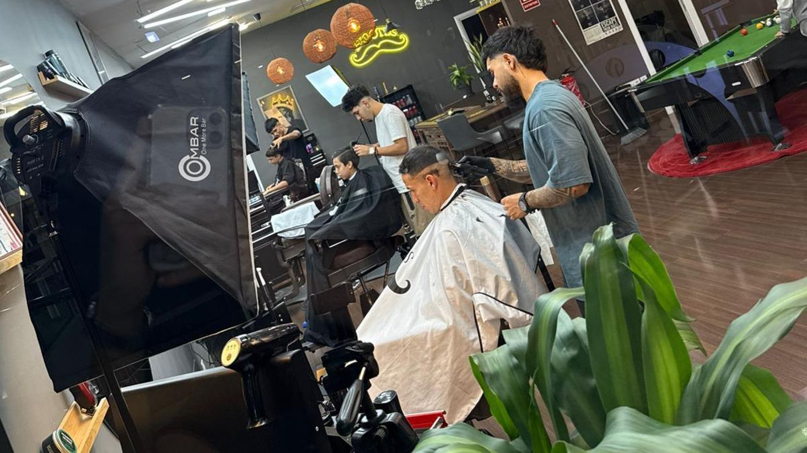 Kevin González cortándole el pelo a un cliente en su Bigotes Study.