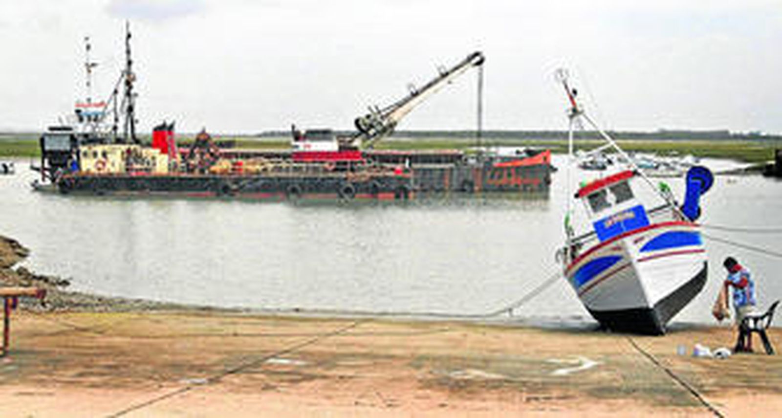 La draga trabajaba ayer frente al puerto pesquero de Sancti Petri.