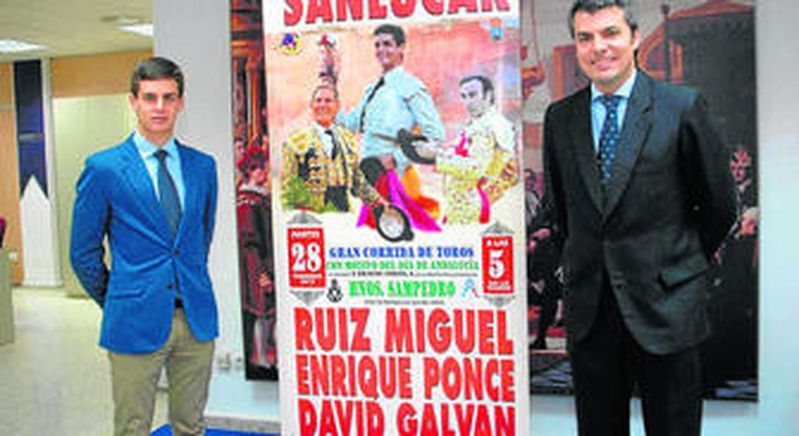David Galván y edil andalucista Francisco Romero junto cartel taurino que anuncia la alternativa del novillero.