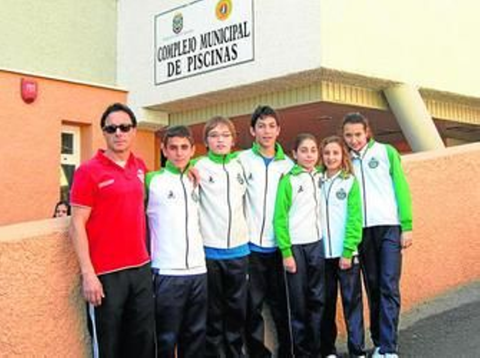 Los seis nadadores isleños junto a Pachi Arce en la puerta de la piscina motrileña.