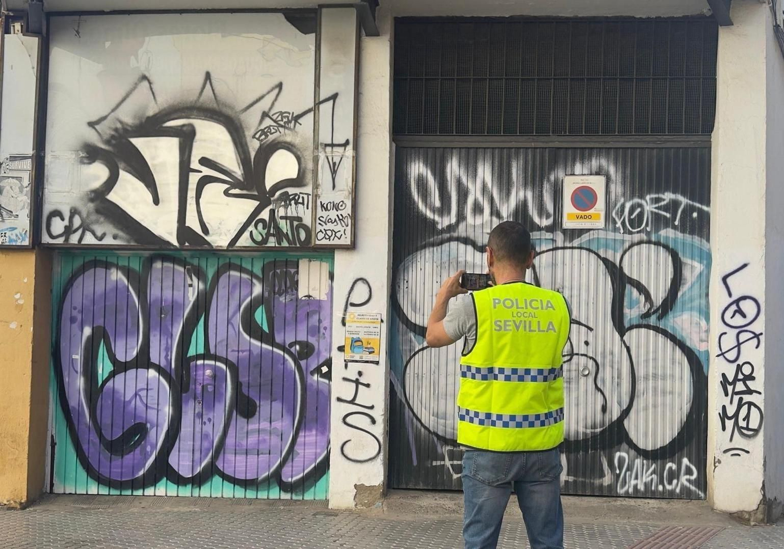Un policía local fotografía algunas pintadas en la vía pública.