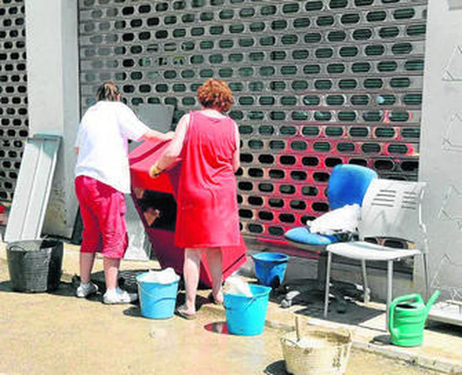 Dos vecinas de Bujalance limpian algunos de sus enseres.