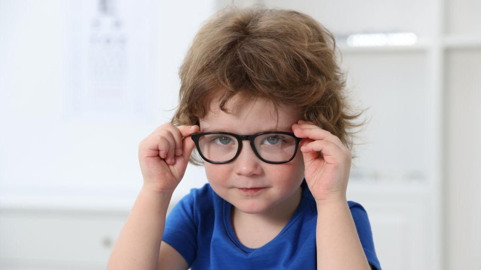 Un niño se pone las gafas.