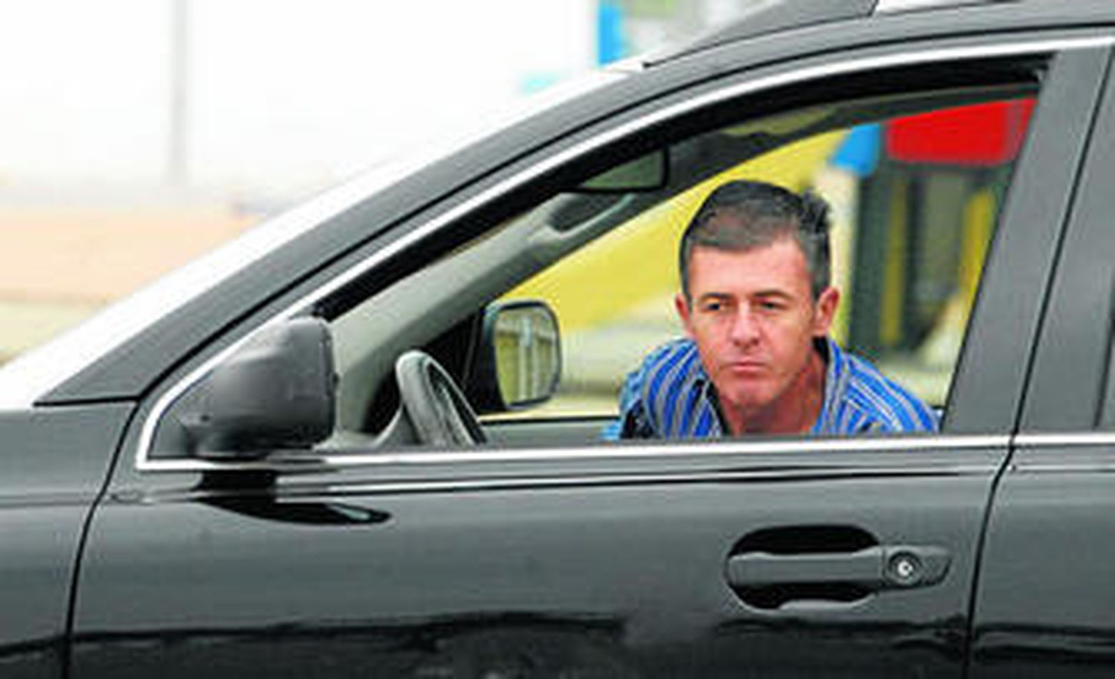 Lucas Alcaraz se asoma desde el interior de su coche en los aledaños de El Arcángel, ayer al mediodía.